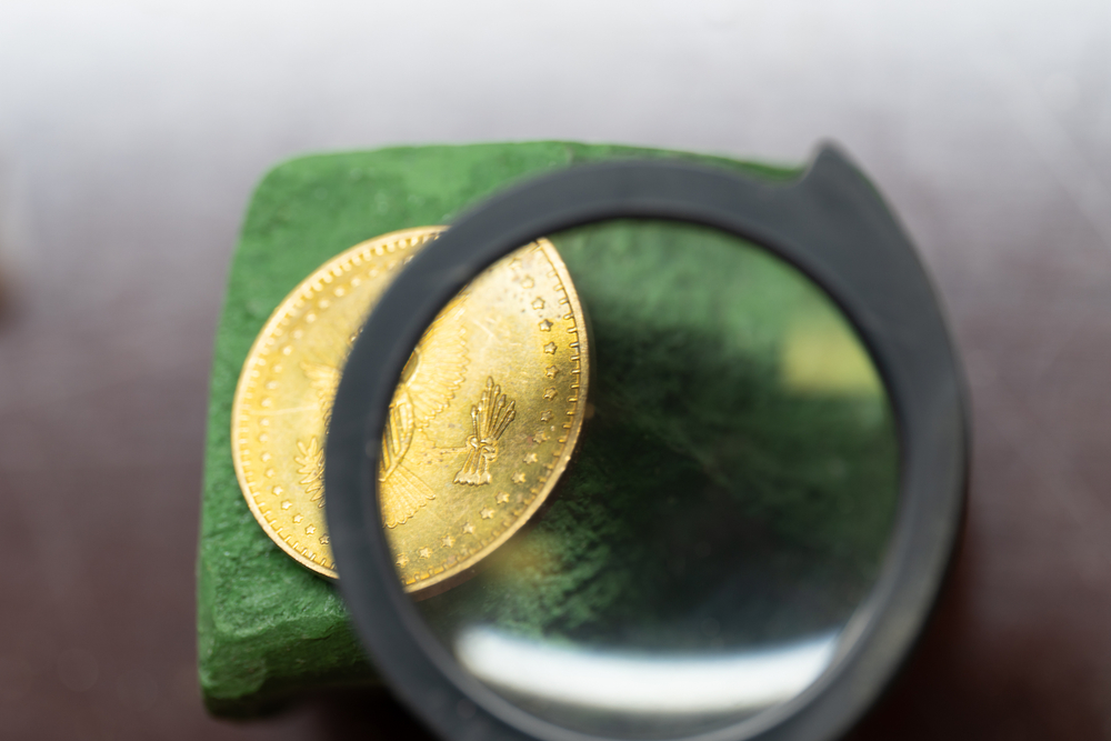 Old gold coin viewed through a magnifying glass